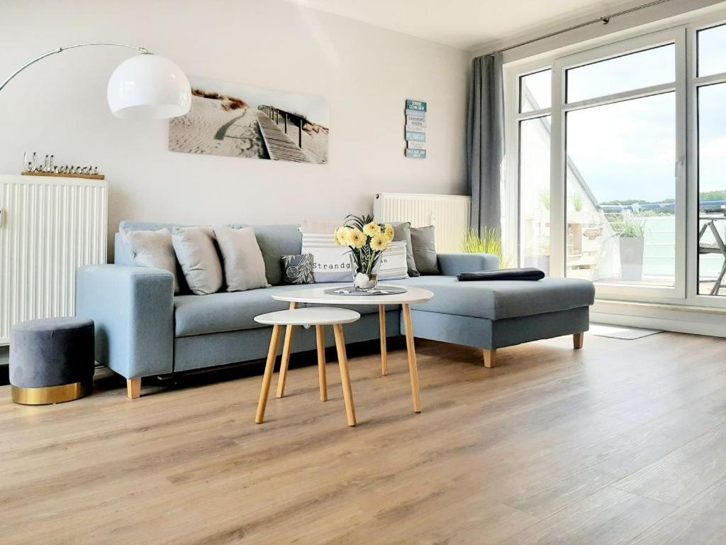 a living room with a blue couch and a table at Haffblick Whg Ha16 in Boltenhagen
