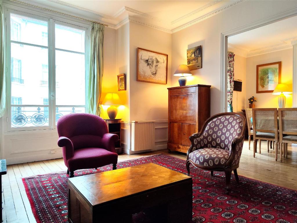 un salon avec deux chaises et une table dans l'établissement Square Desaix - Paris 15, à Paris