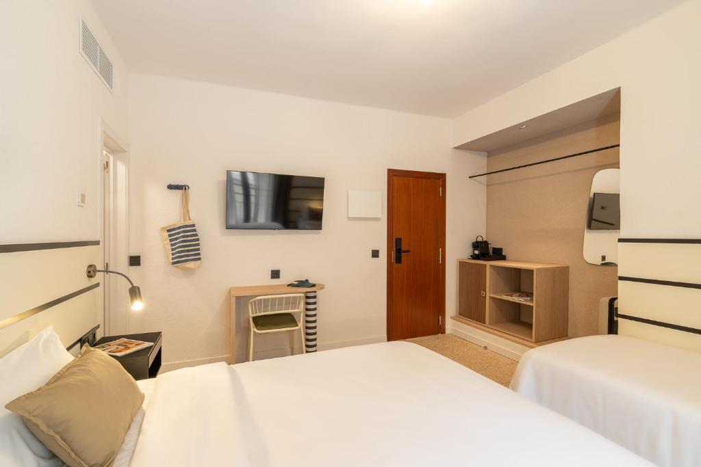 a hotel room with two beds and a desk at Hotel Robson - Smart Hotel in Lloret de Mar