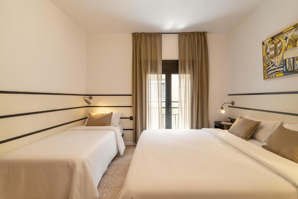 a hotel room with two beds and a window at Hotel Robson - Smart Hotel in Lloret de Mar