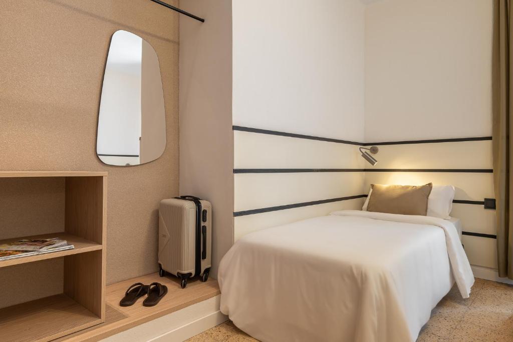 a bedroom with a white bed and a mirror at Hotel Robson - Smart Hotel in Lloret de Mar