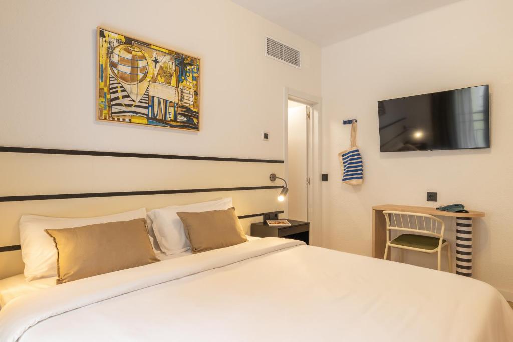 a bedroom with a large white bed and a tv at Hotel Robson - Smart Hotel in Lloret de Mar