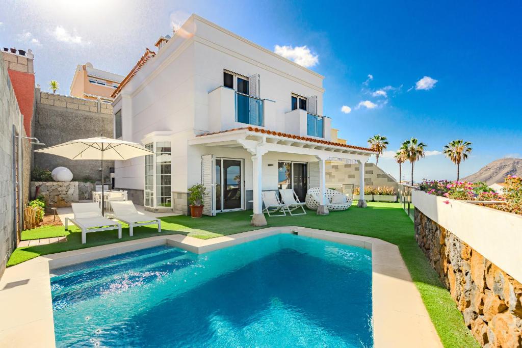 a villa with a swimming pool in front of a house at Villa Casablanca by Welcome Tenerife in Chayofa