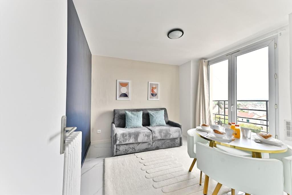 un salon avec une table et un canapé dans l'établissement Séjour Authentique près de Paris à Gagny - II, à Gagny