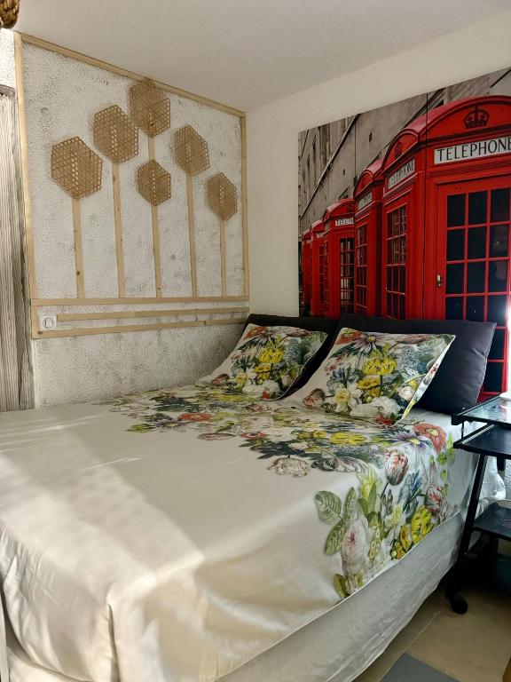 une chambre avec un lit avec deux cabines téléphoniques rouges dans l'établissement Appartement rez-de-chaussée, à Sainte-Maxime