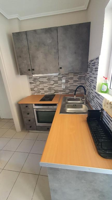 a kitchen with a sink and a wooden counter top at Elite Port in Piraeus