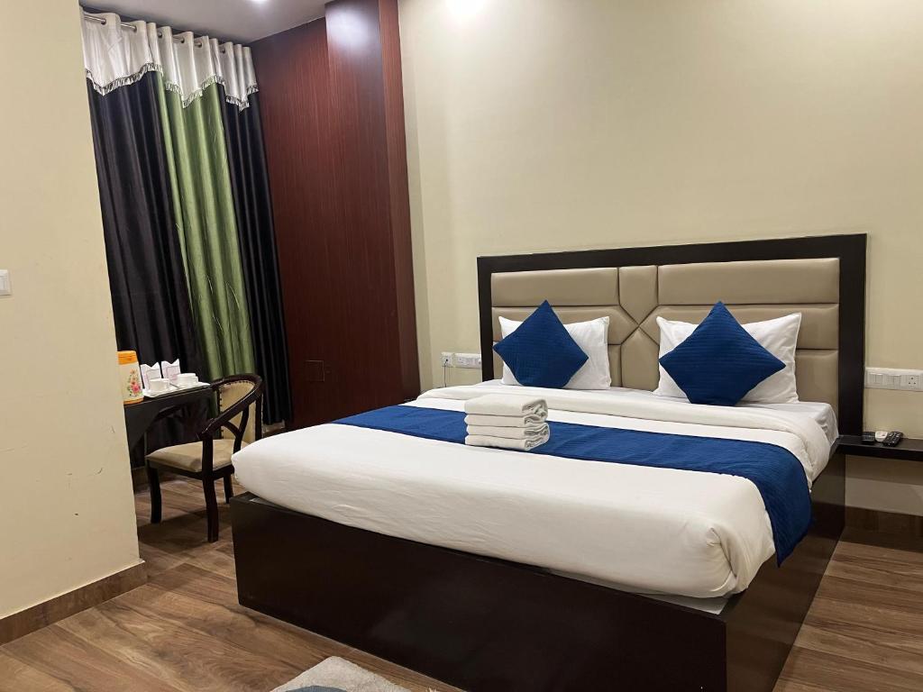 a bedroom with a large bed with blue and white pillows at Mayur Palace Hotel in Agra