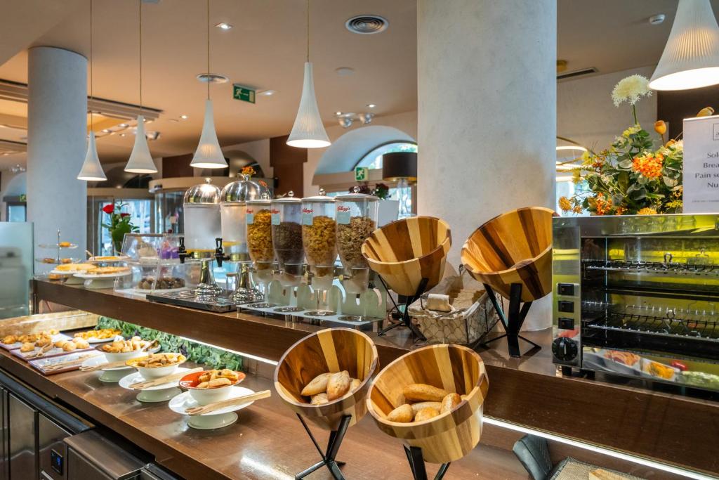 a restaurant with a buffet line with plates of food at Abba Rambla Hotel in Barcelona