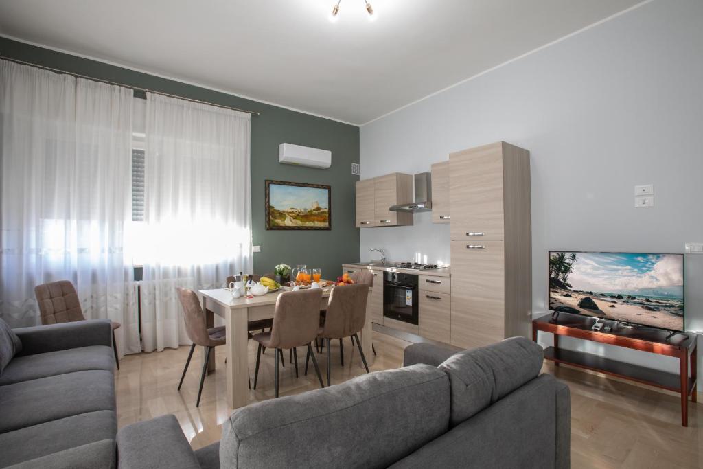a living room with a table and a kitchen at Casa del Sole - Holiday Home in Diso