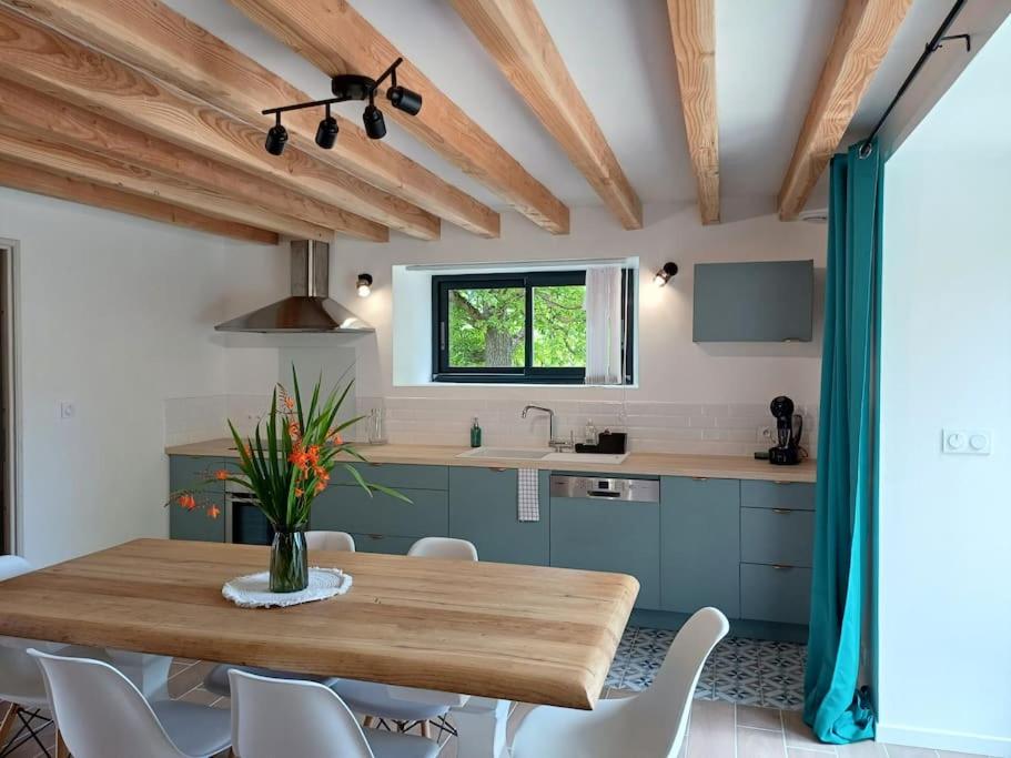 ColombiersにあるL'orée du boisのキッチン(木製テーブル、白い椅子付)