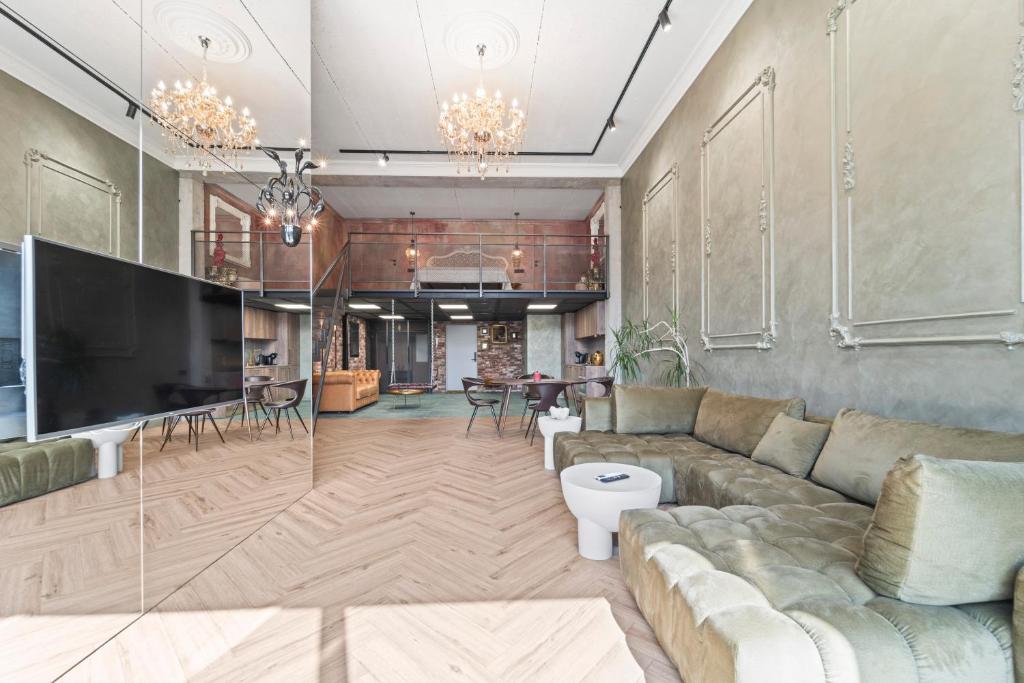 a living room with a couch and a tv at ALL - Amberstone Lux Loft in Klaipėda