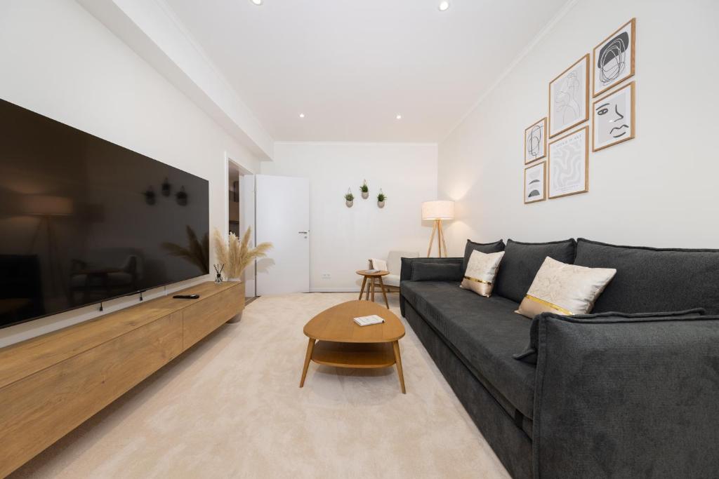 Hotel 120sqm & 5-room luxury apartment with 2 bathrooms, a living room with a black couch and a large tv at 120sqm & 5-room luxury apartment with 2 bathrooms in Berlin