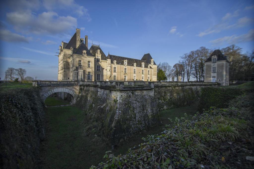a large castle on a bridge over a river at Chateau De Jalesnes in Vernantes