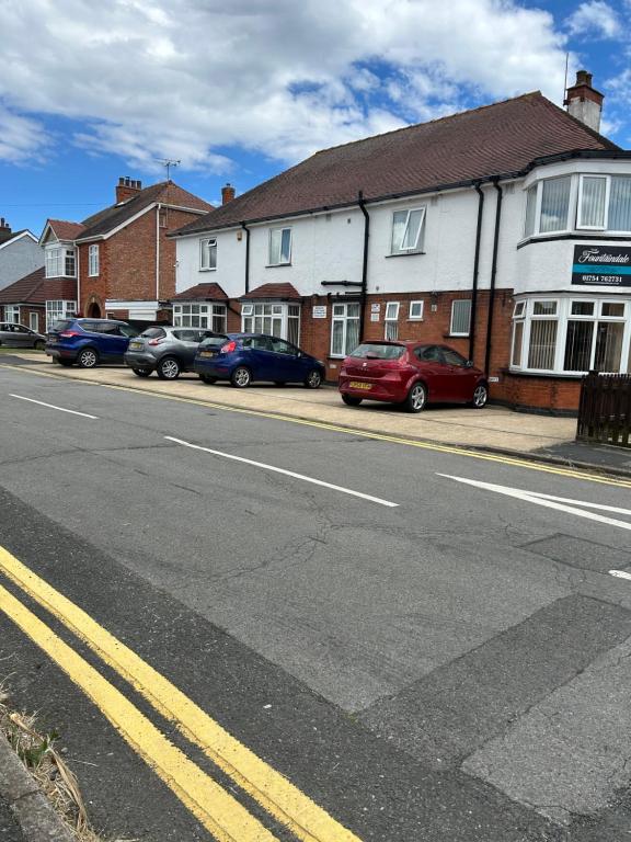 a street with cars parked in front of a building at The Fountaindale Skegness in Skegness