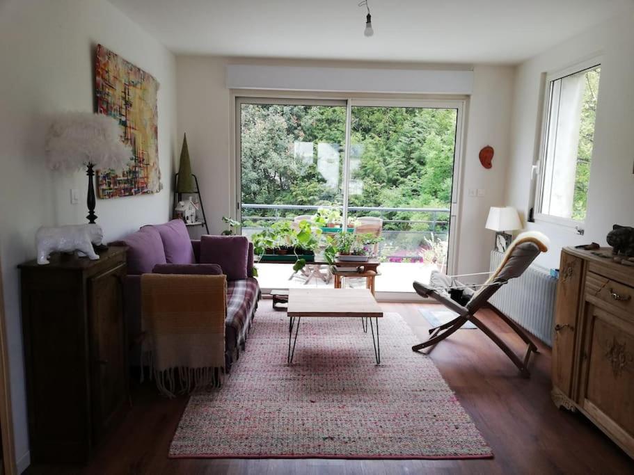 un salon avec un canapé et une table dans l'établissement Maison des fontaines, calme spacieuse avec grand jardin, à Lannion