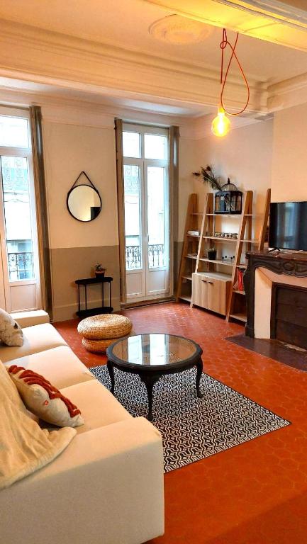 un salon avec un canapé blanc et une table dans l'établissement Appartement Allées Paul Riquet, à Béziers