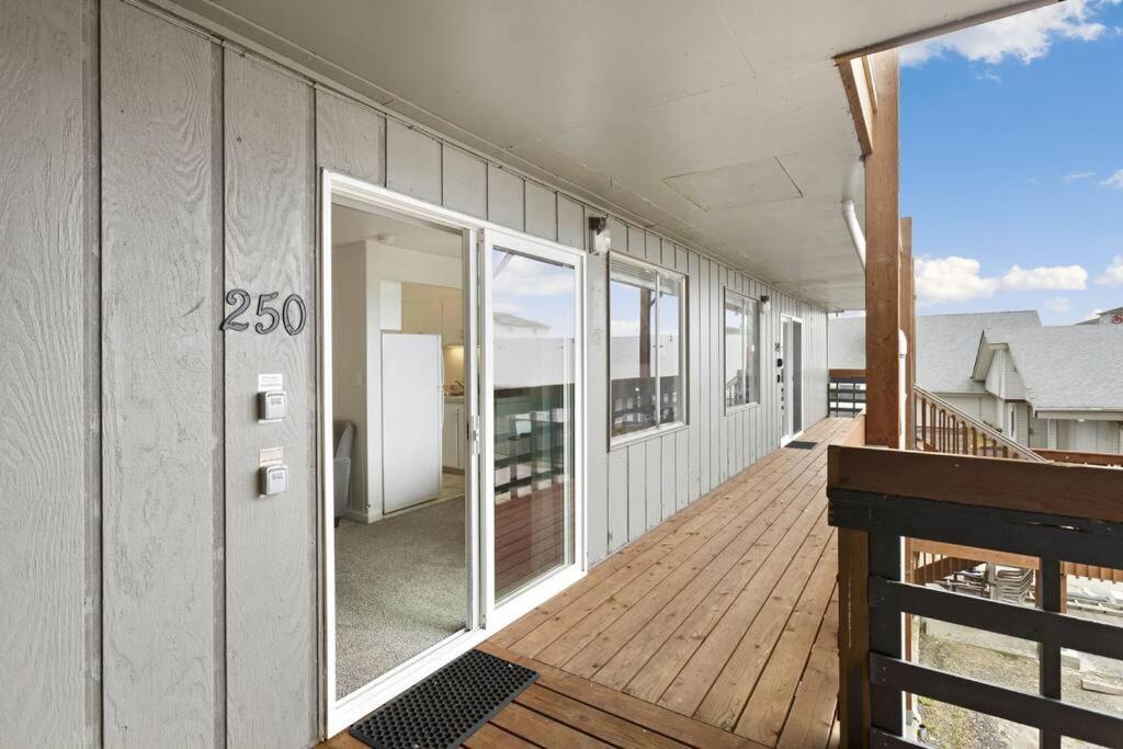 オーシャン・ショアーズにあるSeaside Moon Condo #250のバルコニー付きの木製デッキのある建物