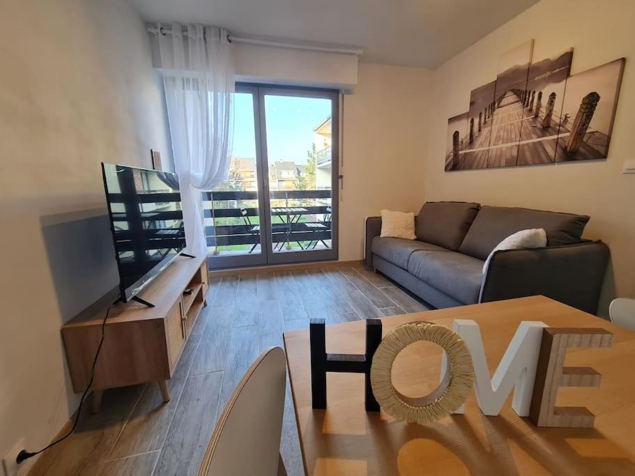 un salon avec un canapé et une télévision dans l'établissement Convivialité agréable séjour au calme, à Cabourg