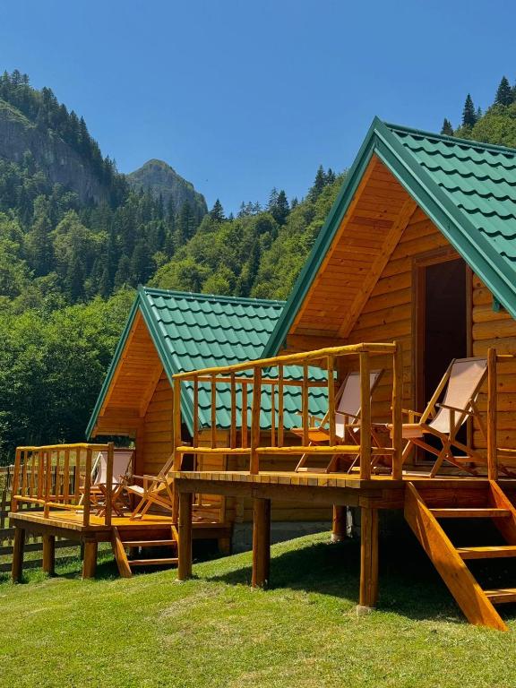 a cabin with a deck and chairs in front of it at Mountain Retreat Jelovica in Kolašin