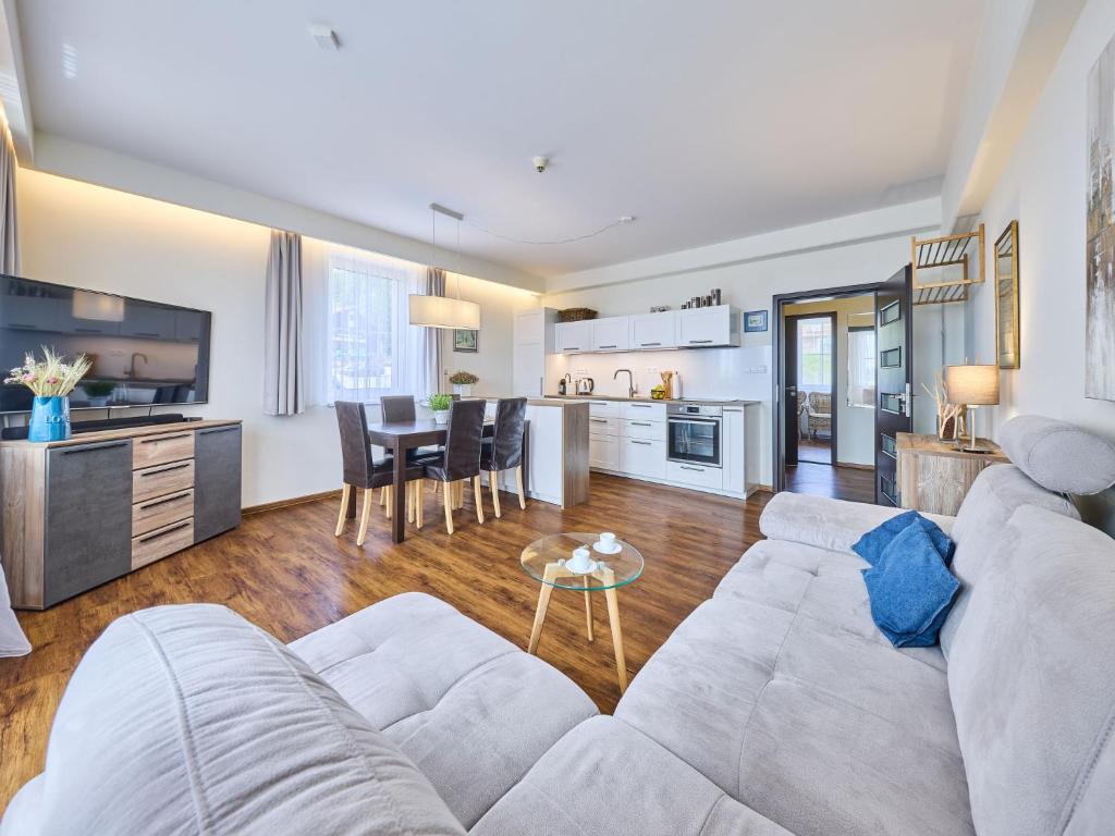 a living room with a white couch and a kitchen at Apartment Horní Mísečky-2 by Interhome in Vítkovice