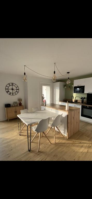 une cuisine avec une table et des chaises dans une pièce dans l'établissement Appartement Lumineux Anglet, à Anglet