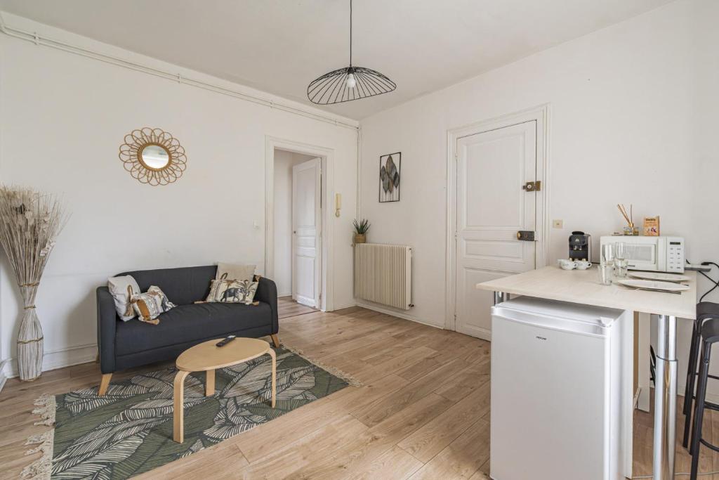 un salon avec un canapé et une table dans l'établissement Pentagone 23 Stade de Reims, à Reims