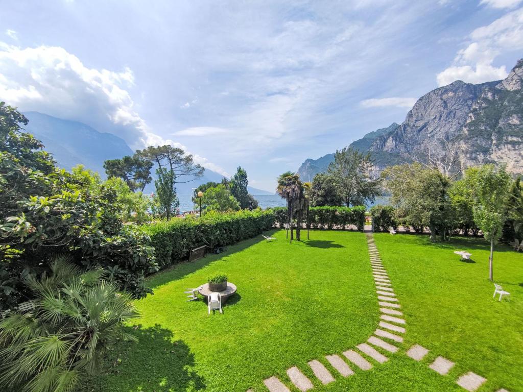 a green park with mountains in the background at Apartment Am See by Interhome in Riva del Garda