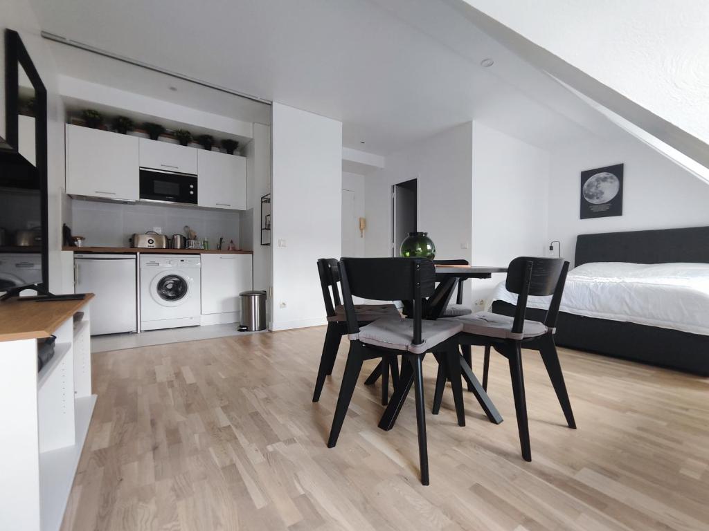 une cuisine et une salle à manger avec une table et des chaises dans l'établissement Rue de Berri - Paris 8, à Paris