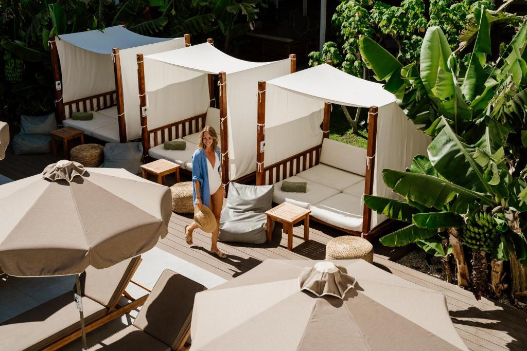 a woman standing in front of two beds with umbrellas at Nissi Park Hotel in Ayia Napa