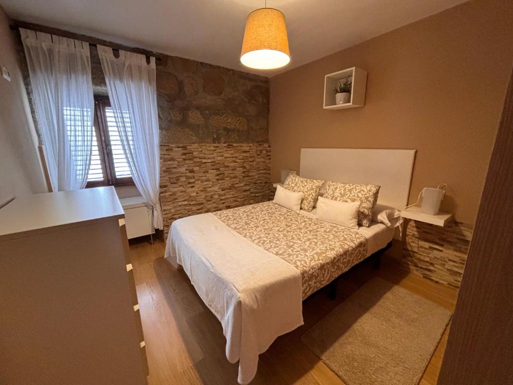 ein Schlafzimmer mit einem Bett und einer Ziegelwand in der Unterkunft Casita rural acogedora in Combarro