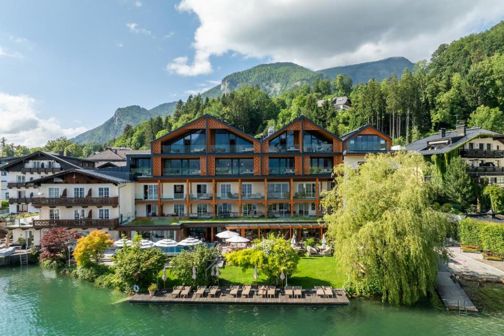 a hotel in the mountains next to a river at Hotel Seevilla Wolfgangsee in St. Wolfgang