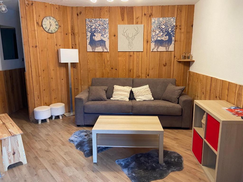 un salon avec un canapé et une table dans l'établissement La Foux d'Allos - Studio 4 couchages - centre station, à Allos