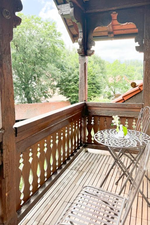 a wooden porch with a table and a chair at Villa Fantasia Budget Boutique Hotel in Füssen