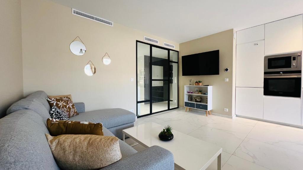 un salon avec un canapé et une table dans l'établissement Super logement - Mer à 5 min à pieds !, à Nice