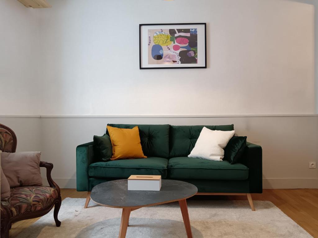 un salon avec un canapé vert et une table dans l'établissement Maison familiale centre-ville 4 chambres mezzanine, à Saint-Brieuc
