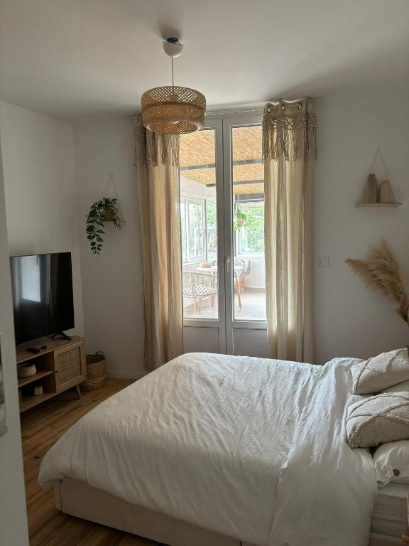 une chambre blanche avec un lit et une télévision dans l'établissement Studio 2, à Avignon