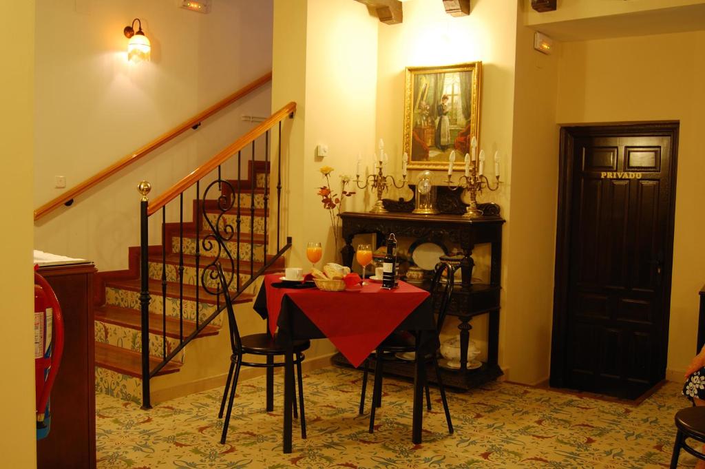 a dining room with a red table and chairs at Un Rincón en la Mancha in Villar de Cañas