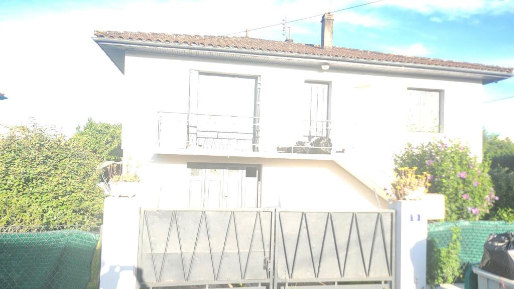 ein weißes Haus mit einem Balkon und einem Zaun in der Unterkunft Sogo in Villeneuve-sur-Lot