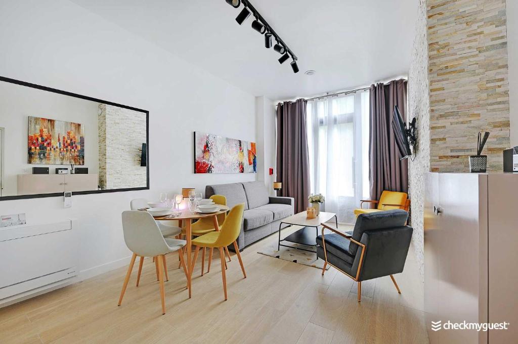 un salon blanc avec une table et des chaises dans l'établissement Intimate Apartment with Air Conditioner & Jacuzzi 2BR 6P Montmartre, à Paris