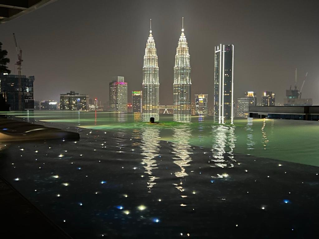 a city skyline with tall skyscrapers at night at Eaton Residence Suites KLCC in Kuala Lumpur