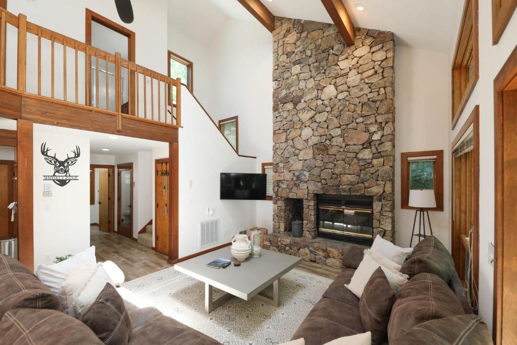 een woonkamer met een bank en een stenen open haard bij Luxury Mountaintop Family Retreat in Lyndhurst