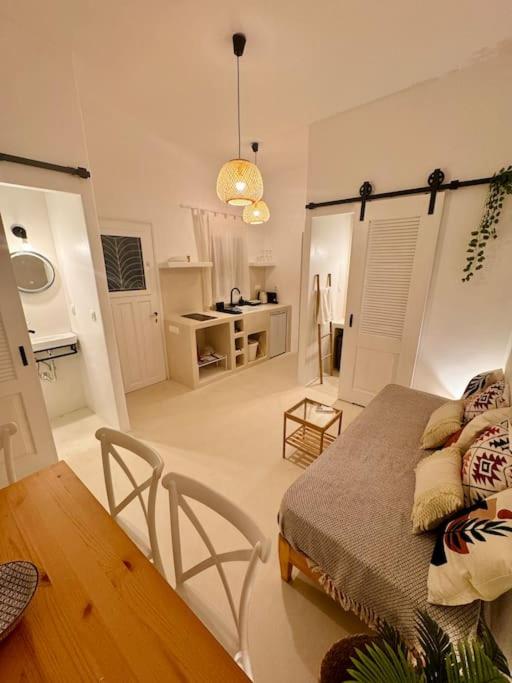 a living room with a bed and a dining room table at Walk The View Apartment with village view in Chora in Ios Chora