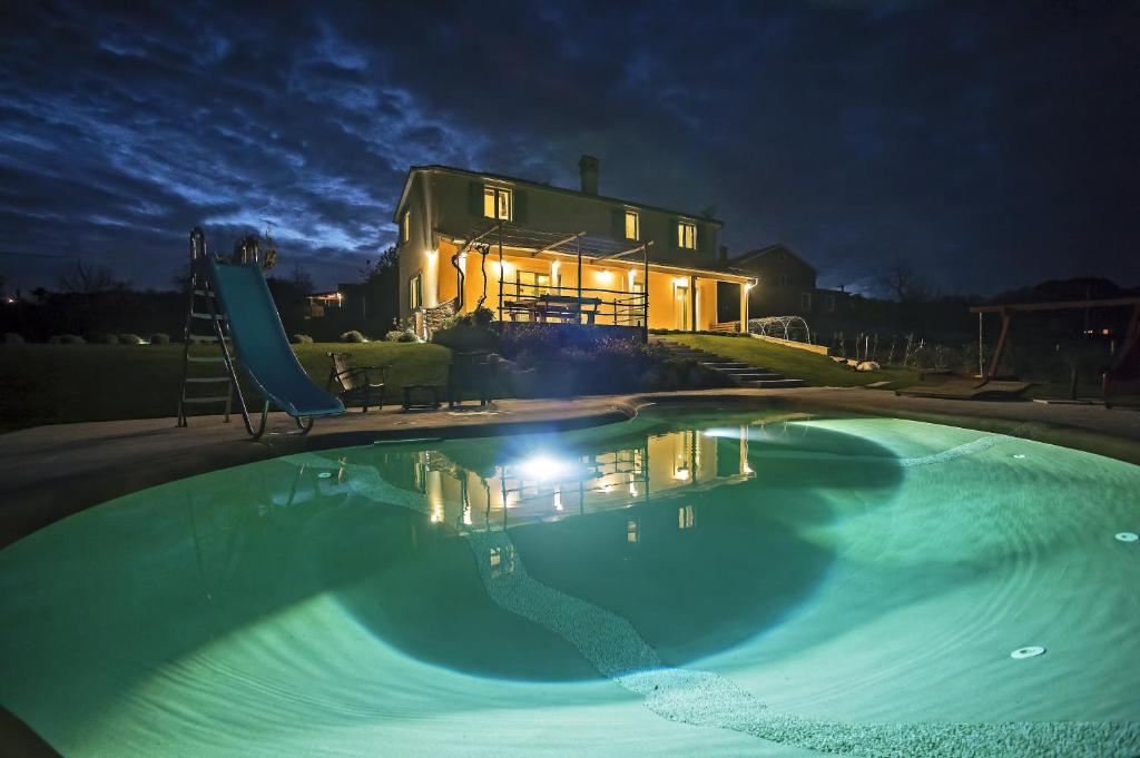 a large swimming pool in front of a house at night at Villa D'Arsa in Gorica
