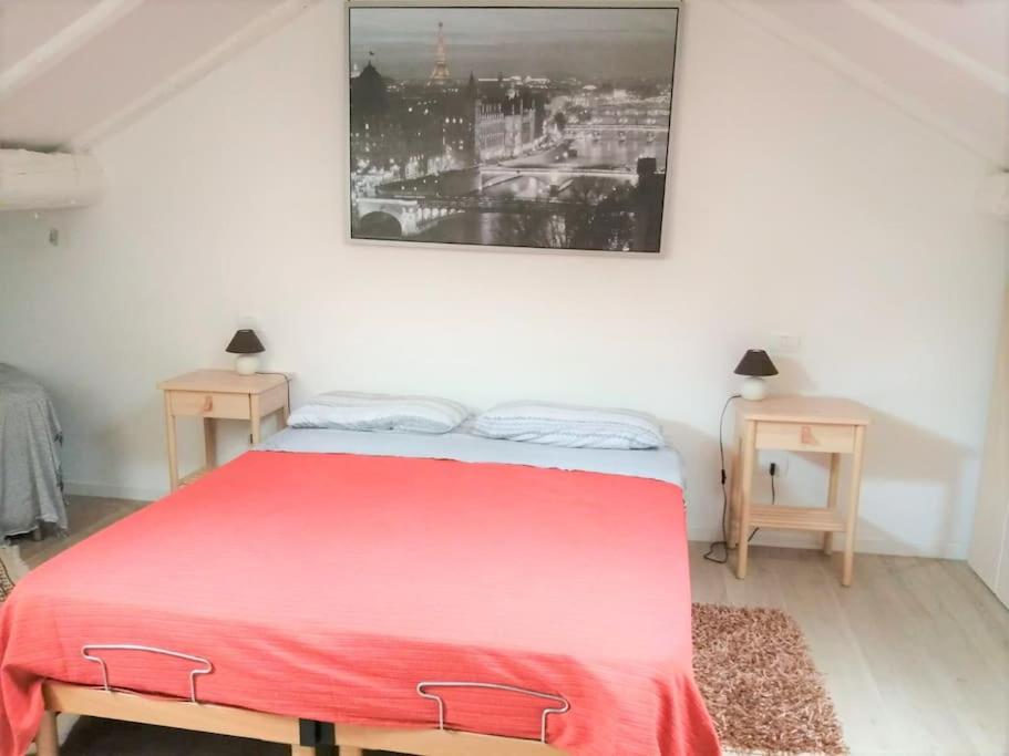 Un dormitorio con una cama roja y dos mesas. en Maison Mirt, en Bolonia