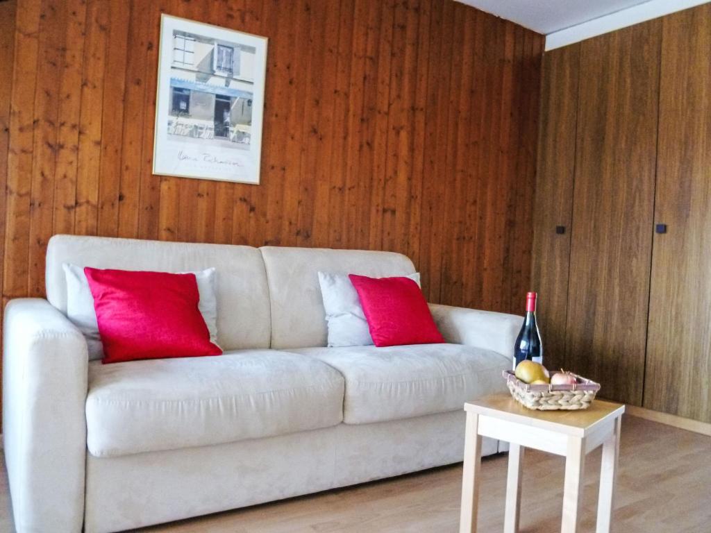 a living room with a white couch and red pillows at Studio Greppon 110 by Interhome in Les Collons