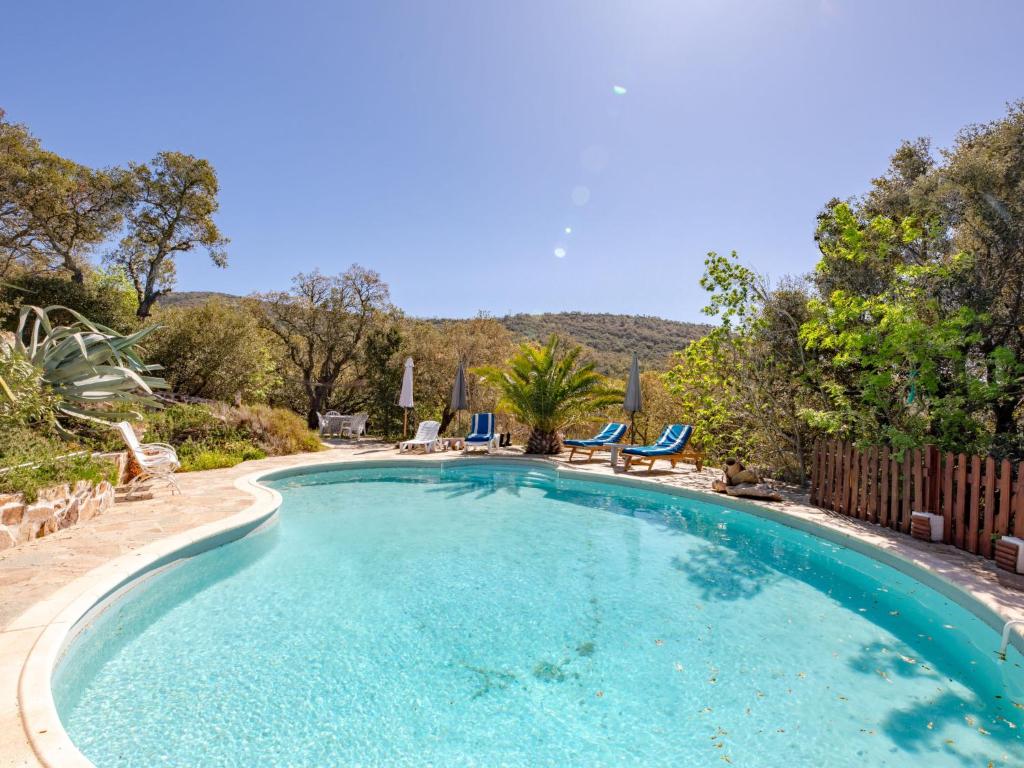 a large swimming pool with chairs in a yard at Holiday Home La Sacherie de l'Autourière by Interhome in La Garde-Freinet