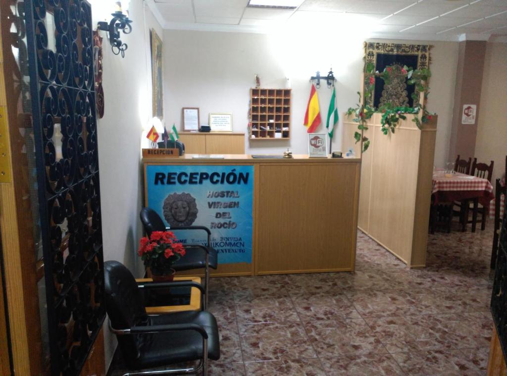 una sala de recepción con sillas y una recepción. en Hostal Virgen Del Rocío en Ronda