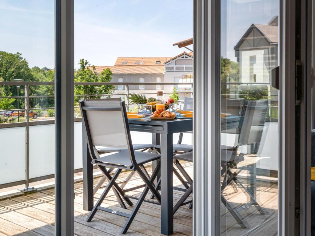 un balcon avec une table et des chaises sur un balcon dans l'établissement Apartment L'Indigo by Interhome, à Pornic