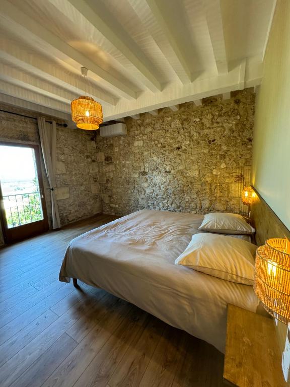 - une chambre avec un lit et un mur en pierre dans l'établissement Villa Monbazillac, vue exceptionnelle, piscine, jacuzzi 10-12 pax, à Monbazillac