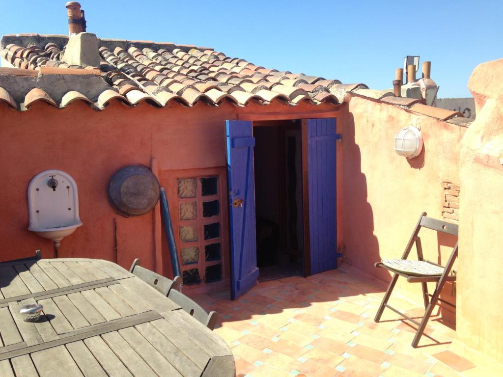 une maison avec une table et des chaises sur une terrasse dans l'établissement Appartement terrasse vue panoramique au coeur du Panier, à Marseille